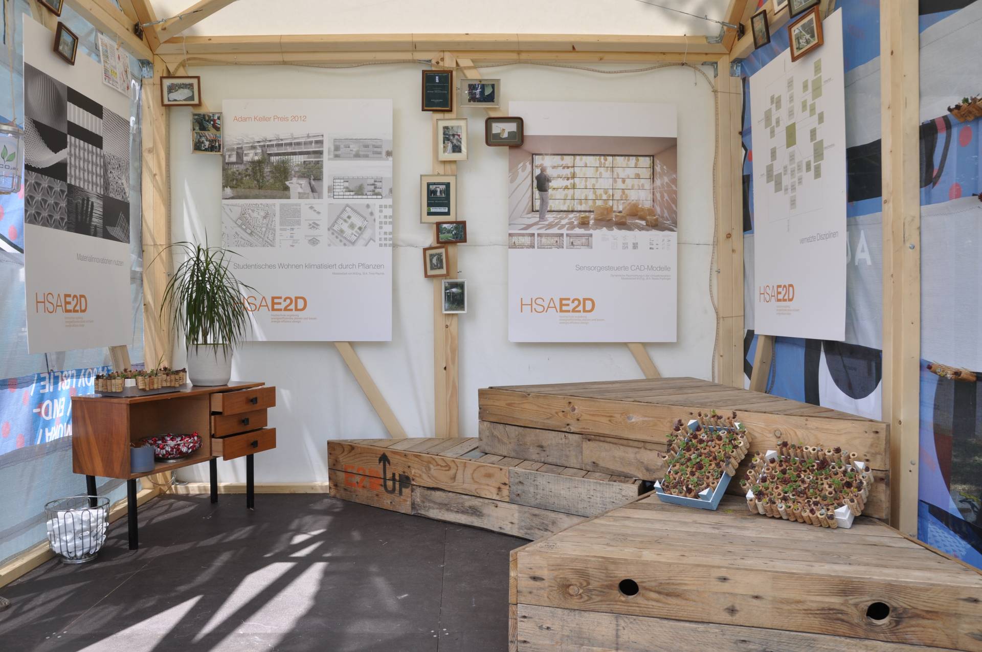 Pavillon des E2D-UP! Projekts mit dreieckigen Bühnen-/ Sitzmodulen aus alten Holzpaletten