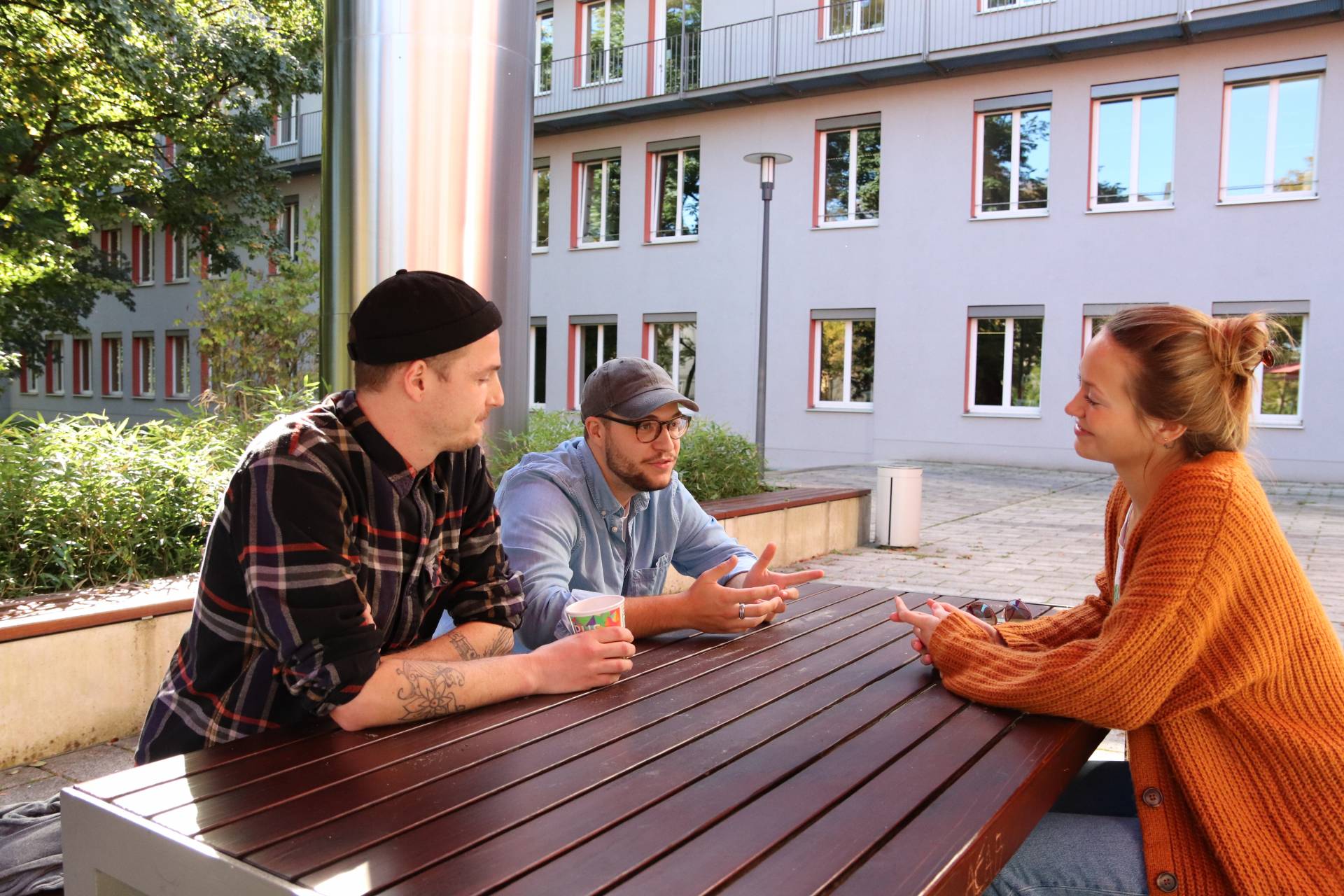 Simon (l.), Kilian (Mitte) und Carolin im Gespräch über den Studiengang Soziale Arbeit. 