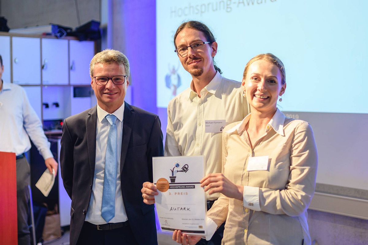 Staatsminister Bernd Sibler (links) überreichte Michael und Margarita Fürmann von der Hochschule Augsburg die Auszeichnung für den dritten Platz beim Hochsprung-Award 2019. Foto: Fabian Stoffers/Hochsprung