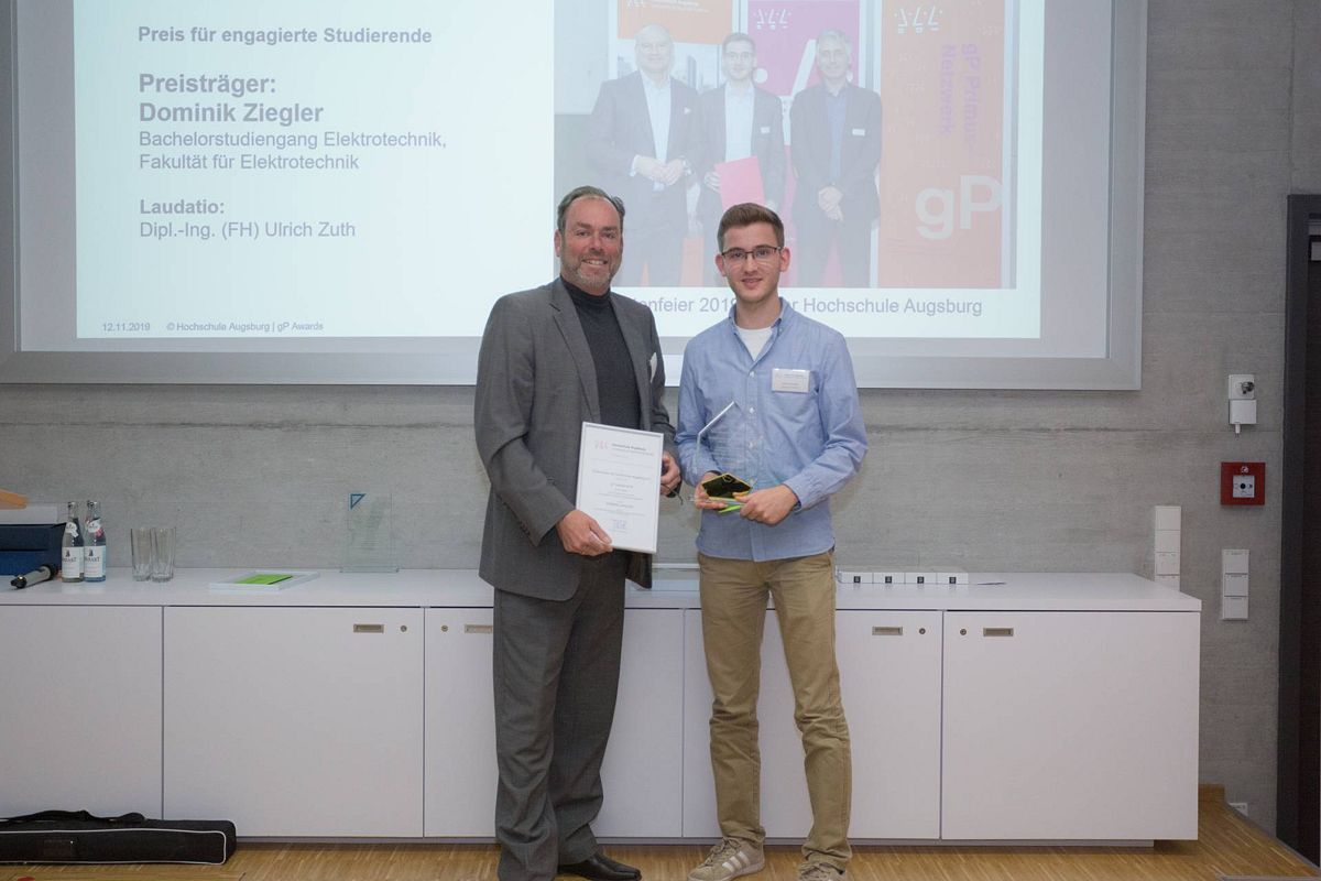 Ulrich Zuth übergibt den Preis zur Förderung der Hochschule Augsburg an Dominik Ziegler.