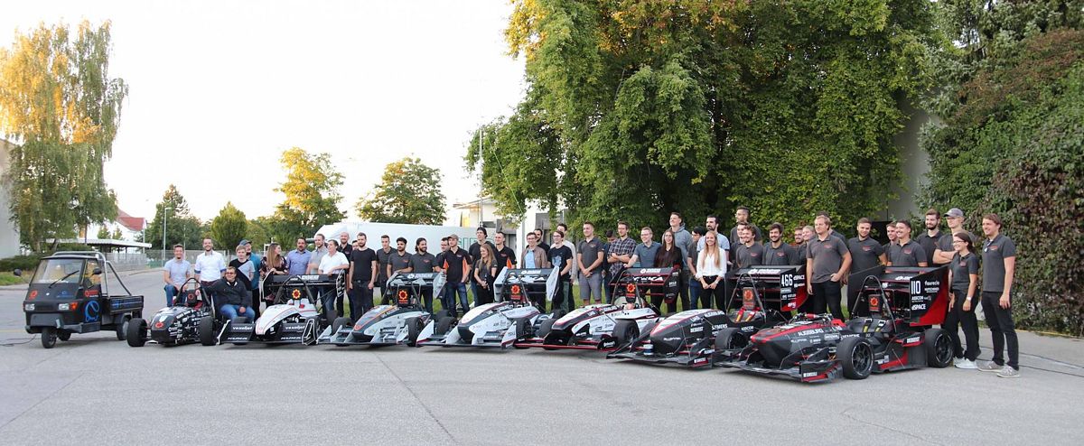 Teammitglieder aus 10 Jahren StarkStrom Augsburg e. V. mit ihren Rennwagen.