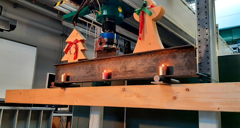 Weihnachtlich geschmückter Balken in Prüfmaschine