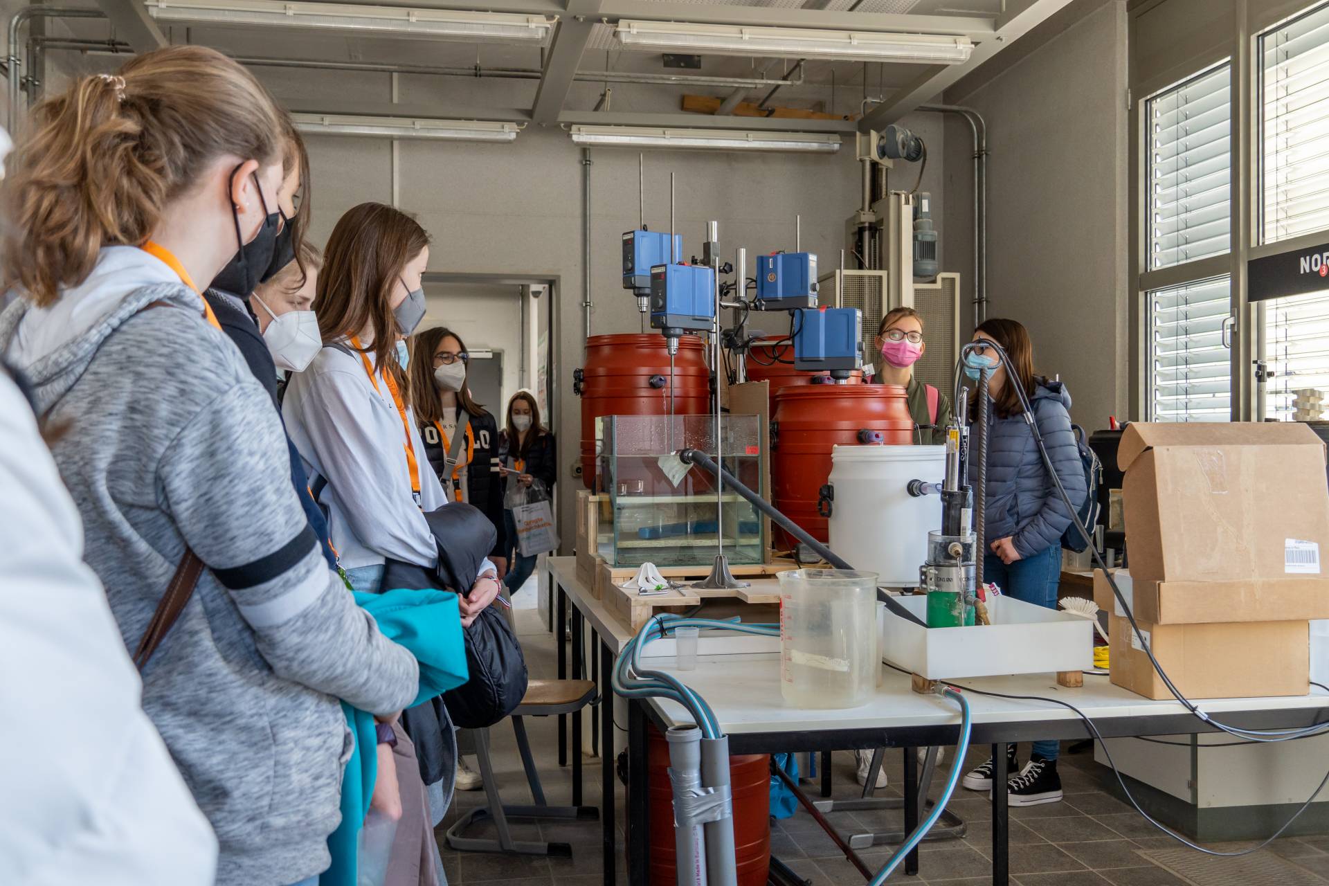 Schülerinnen bekommen Versuchsaufbau in Labor erklärt